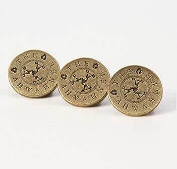 Three circular gold pins with text and a logo