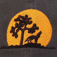 Graphic of a wolf howling at the moon next to a tree