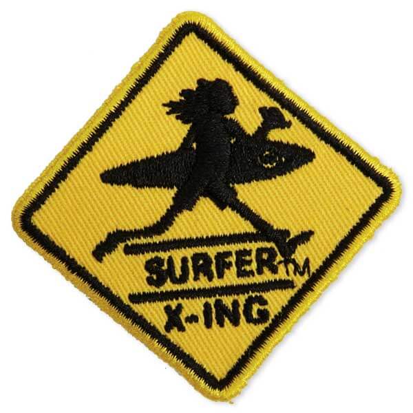 Surfer crossing sign patch in yellow and black with a man and his surf board walking