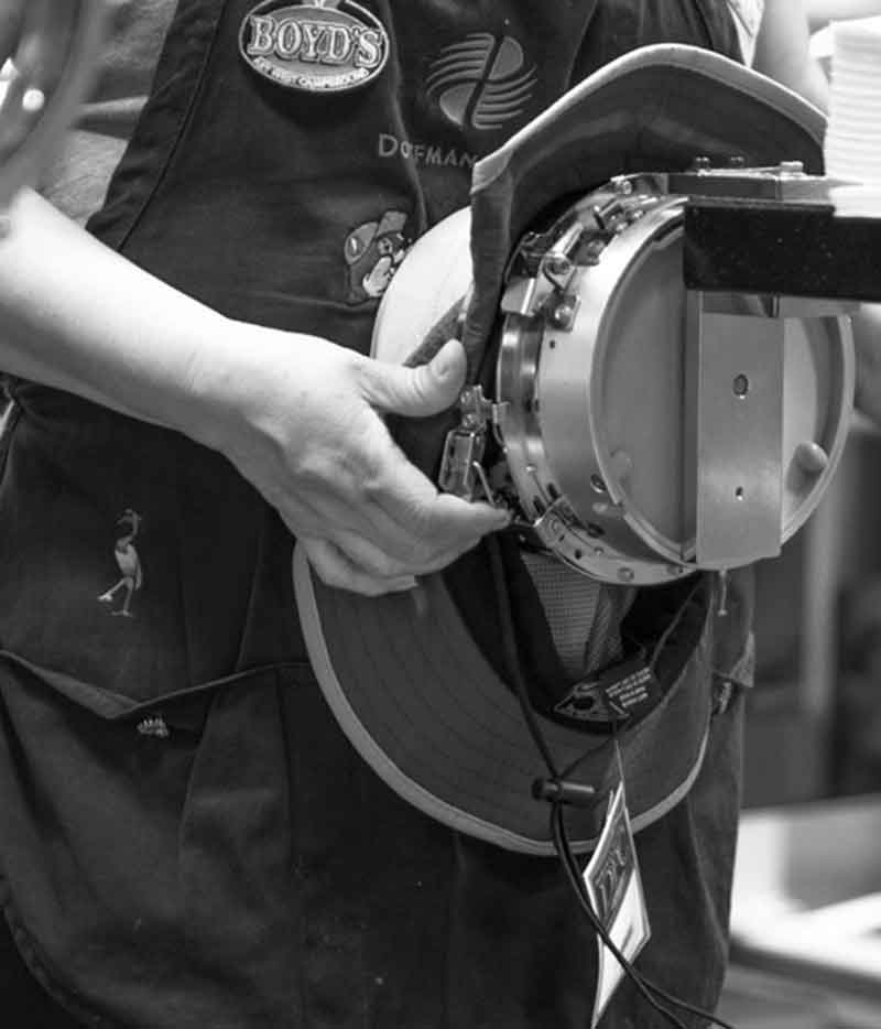Woman working with a hat on a machine