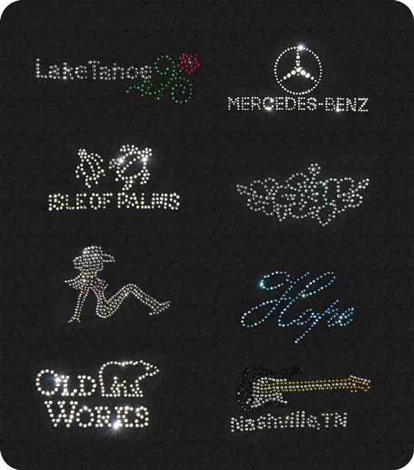 A variety of rhinestone artwork displayed on a black cloth background